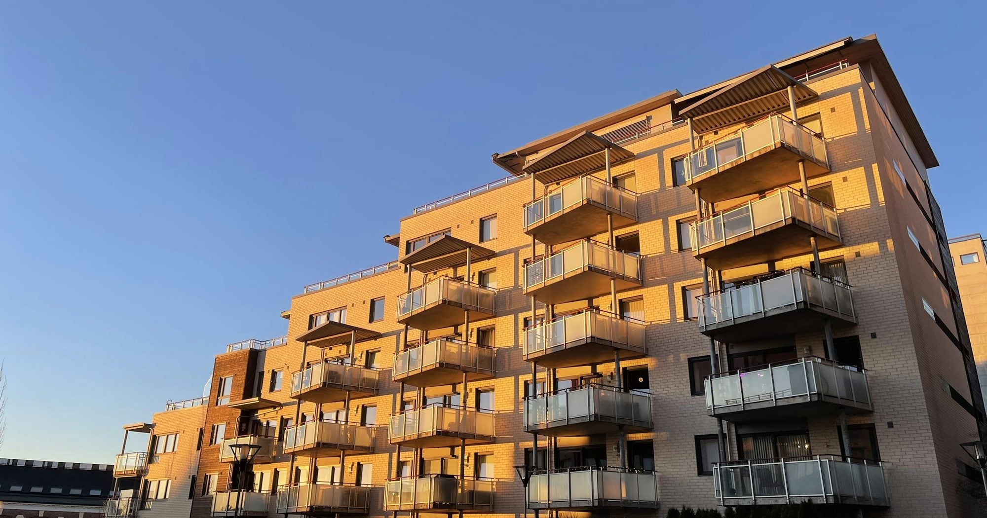 Multifamily apartment building with balconies at golden hour, a typical real estate syndication property